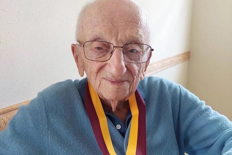 Benjamin Ferencz displays his Harvard Law School Medal of Freedom at the age of 102.