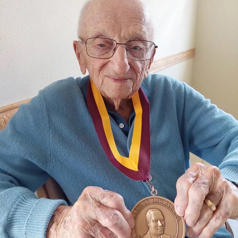 Benjamin Ferencz displays his Harvard Law School Medal of Freedom at the age of 102.