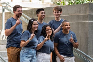 A group of students pose on the steps of a building during orientation.