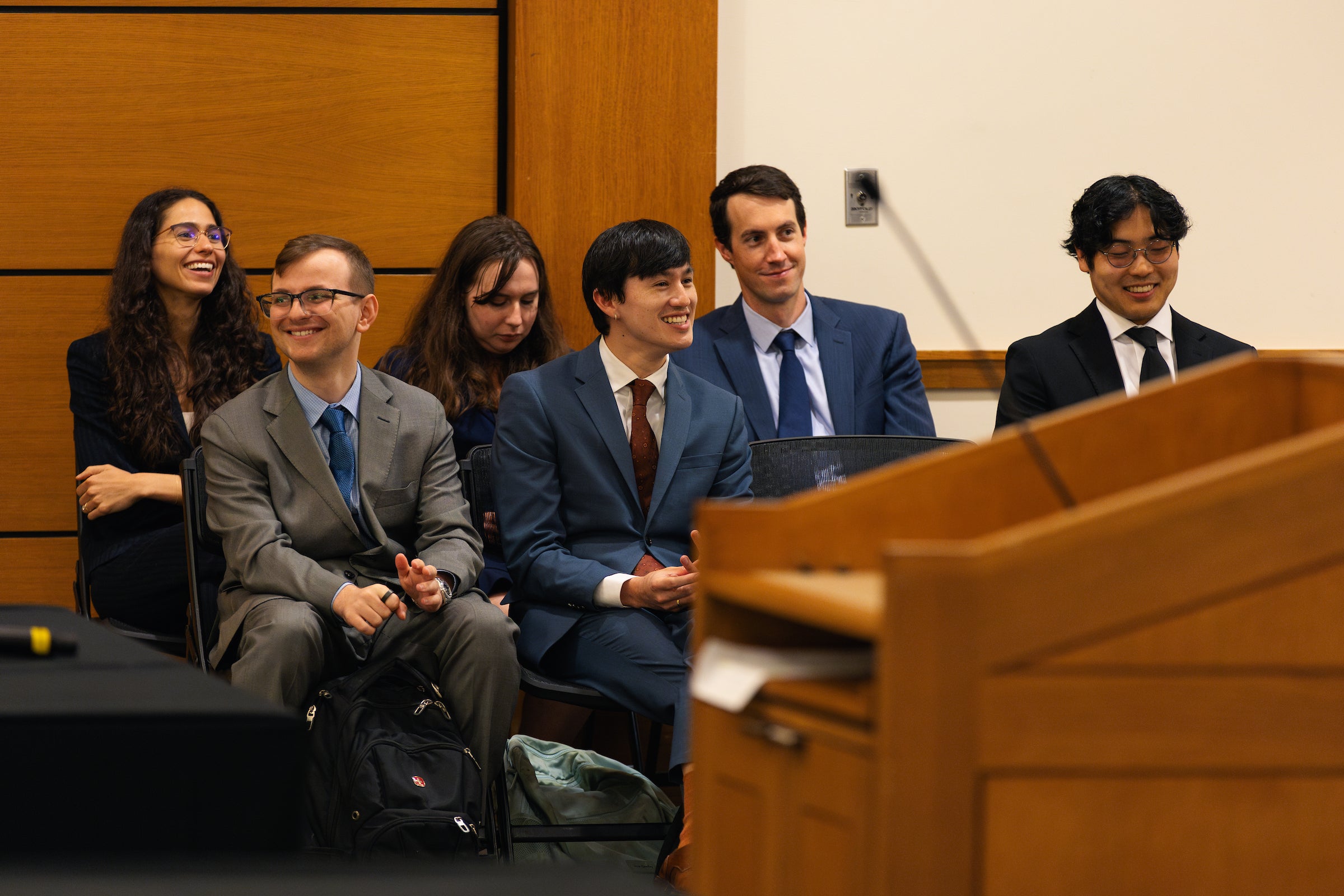 A group of students watches an argument in a courtroom.