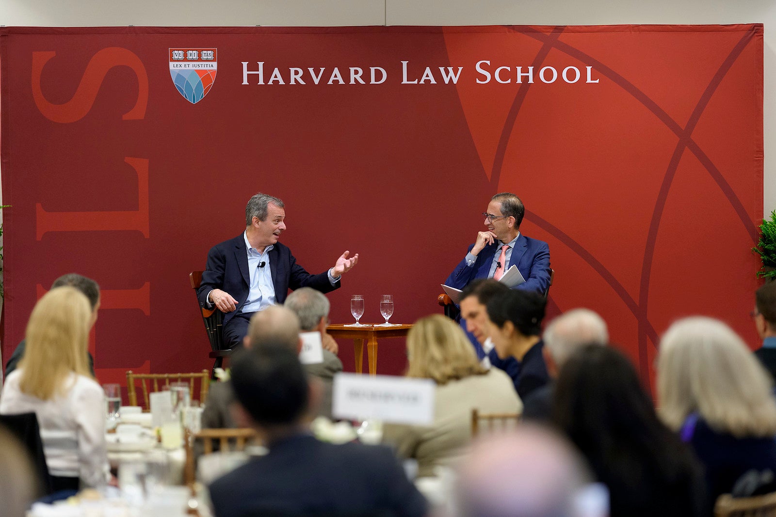 Provost John Manning speaking with Dean John Goldberg on the stage at an event.