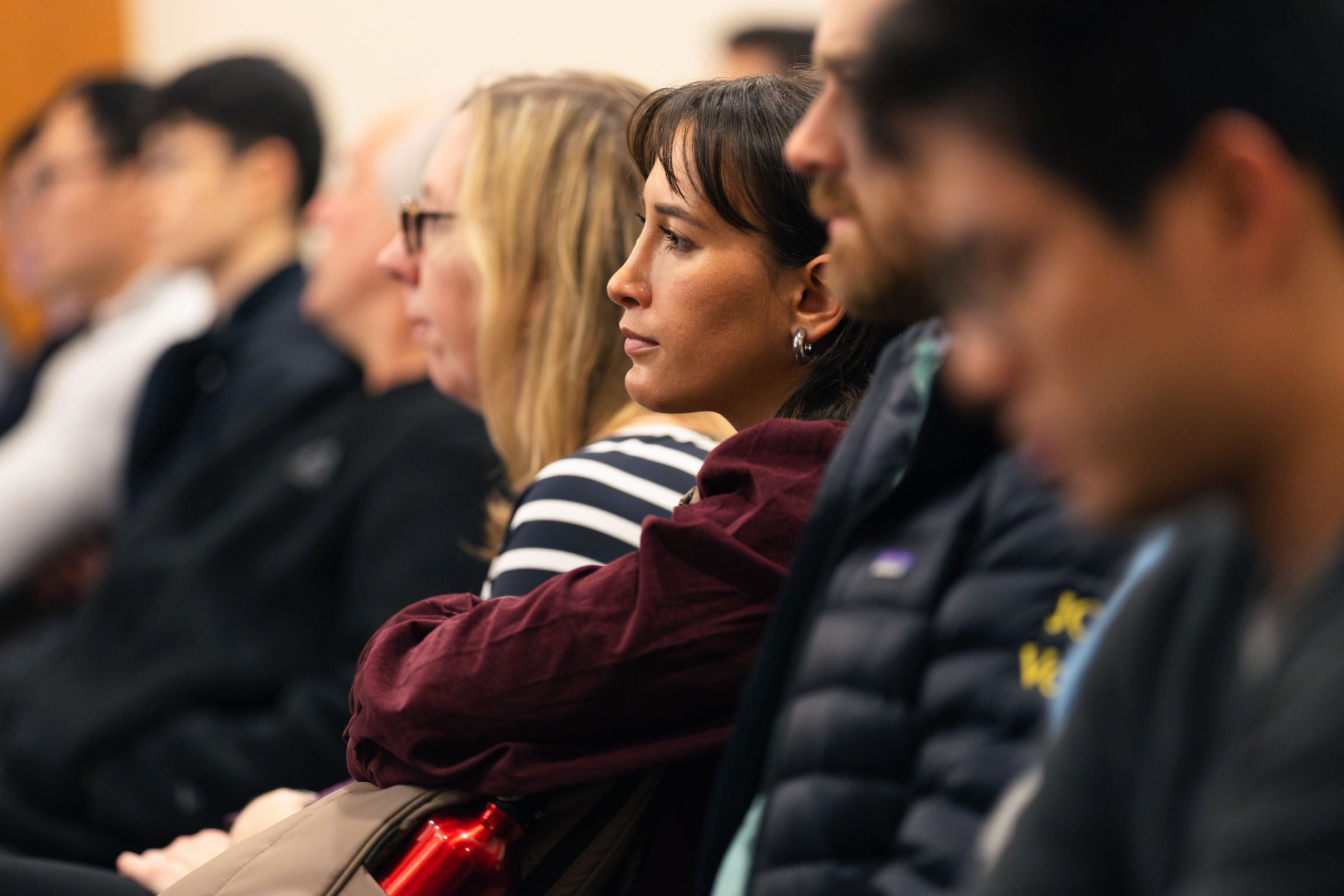 Audience members listen intently.