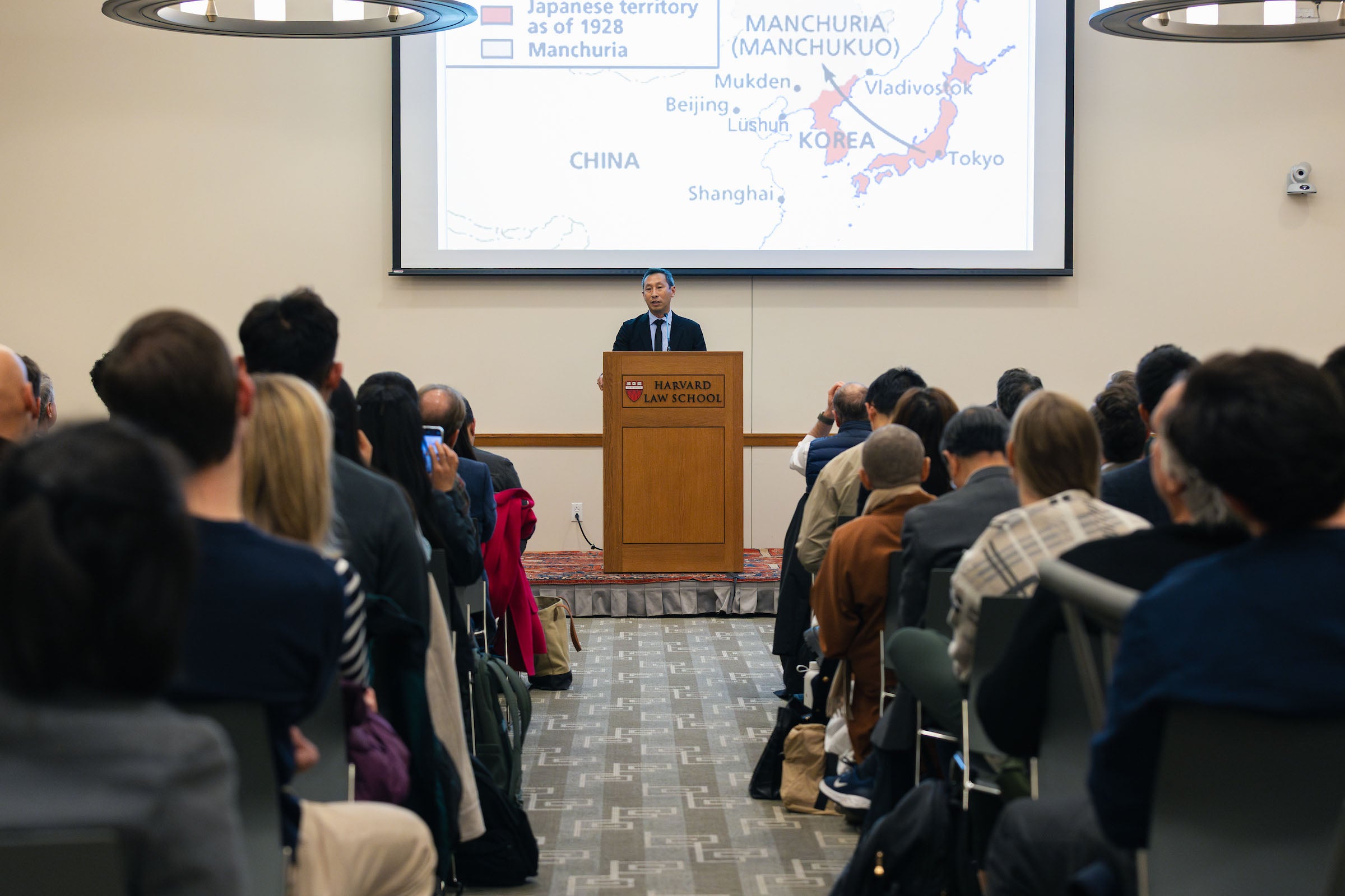Mark Wu addresses the audience as a slide is projected behind him.
