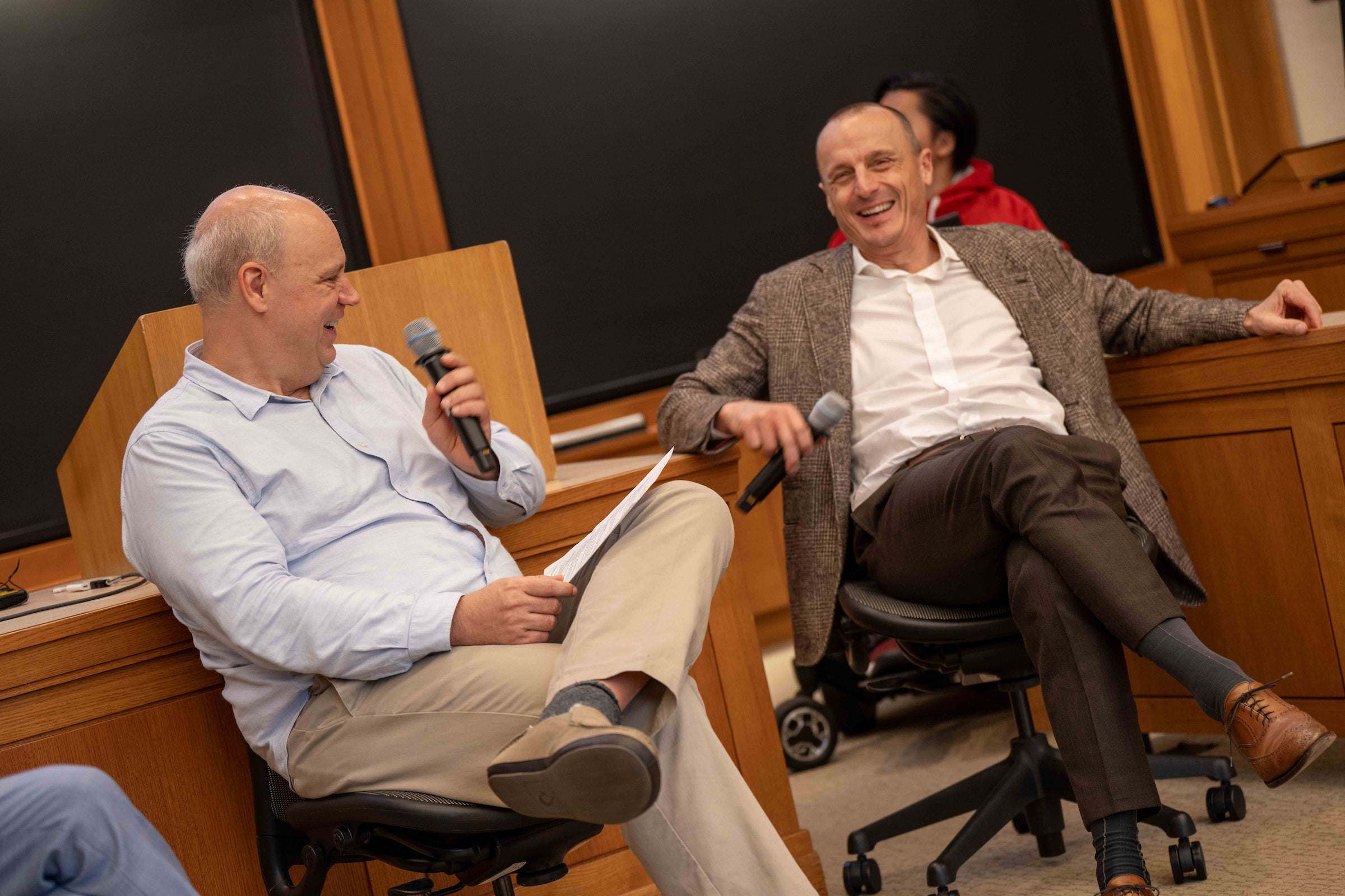 Two men speaking in a classroom.