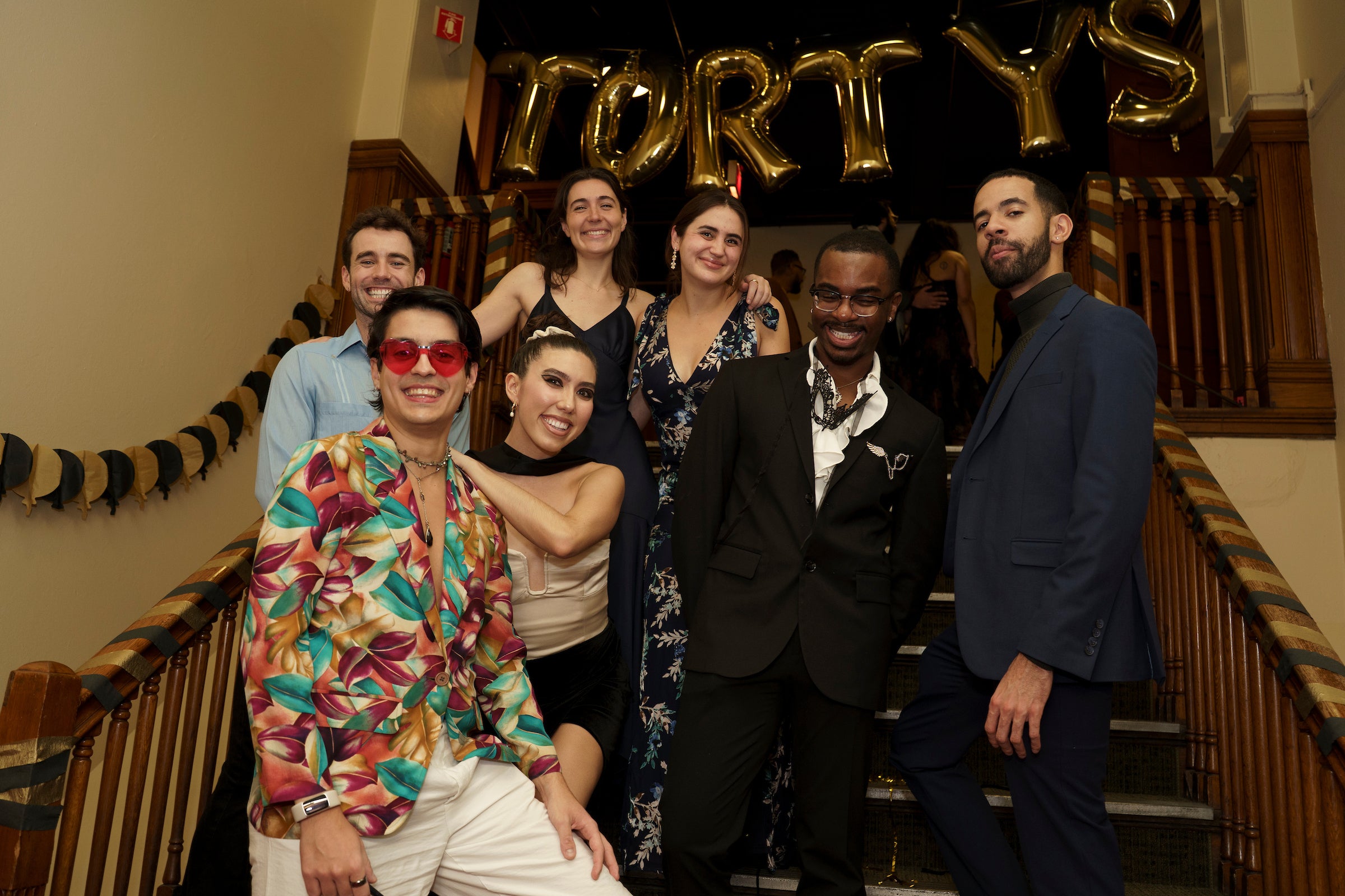 Group of students in dressy outfits pose on the stairs