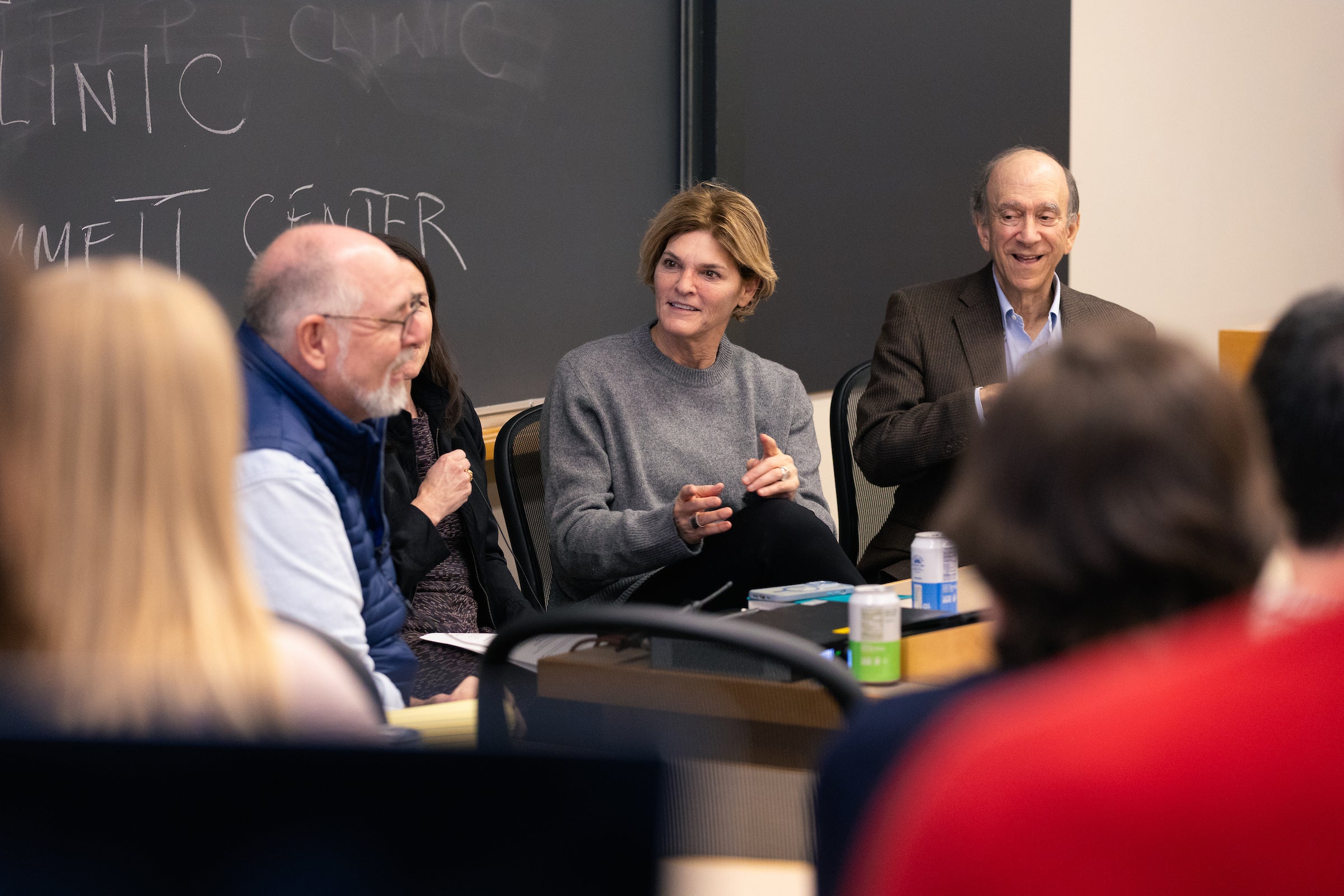 A panel of faculty speak in front of a classroom.