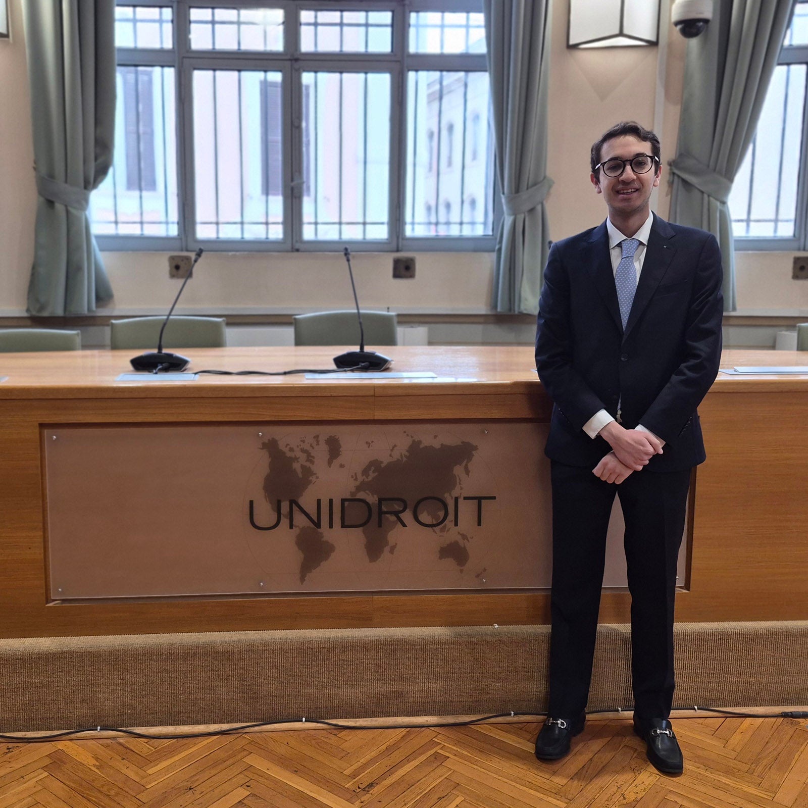 Marco Vita Mesa stands in front of a bench at UNIDROIT.