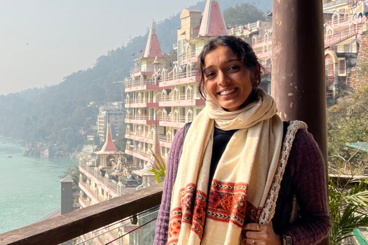 Abhi Nathan on a balcony overlooking a river.
