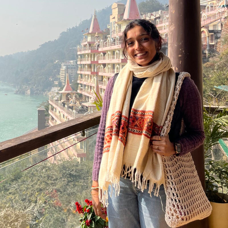 Abhi Nathan on a balcony overlooking a river.