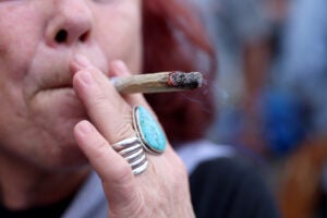 Close up of a woman smoking a marijuana cigarette.