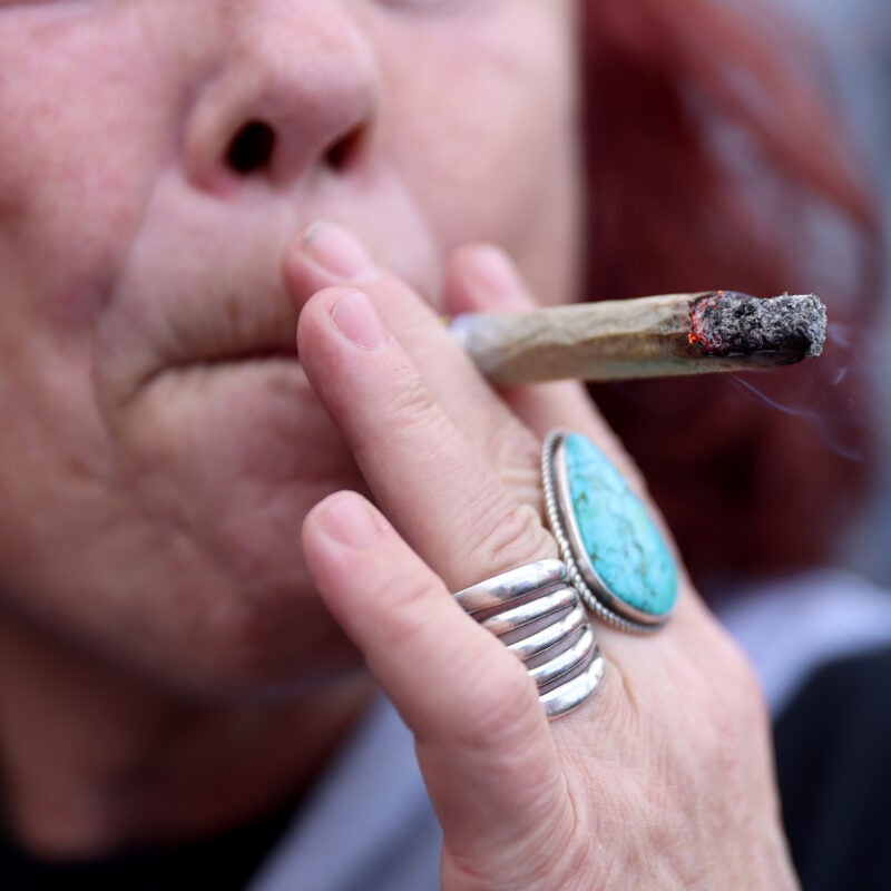 Close up of a woman smoking a marijuana cigarette.