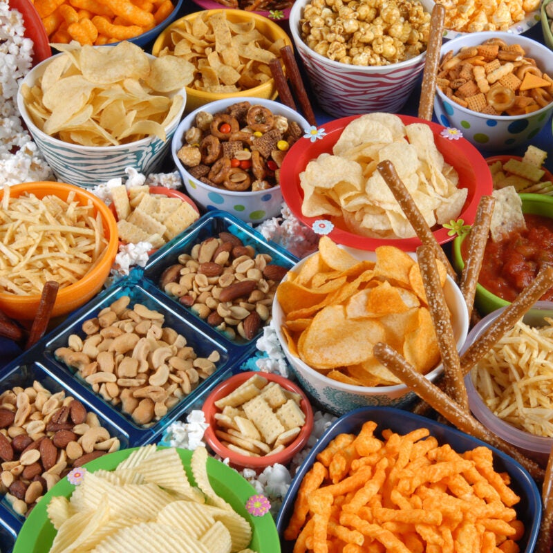 Bowls of chips and other snacks displayed on a table.