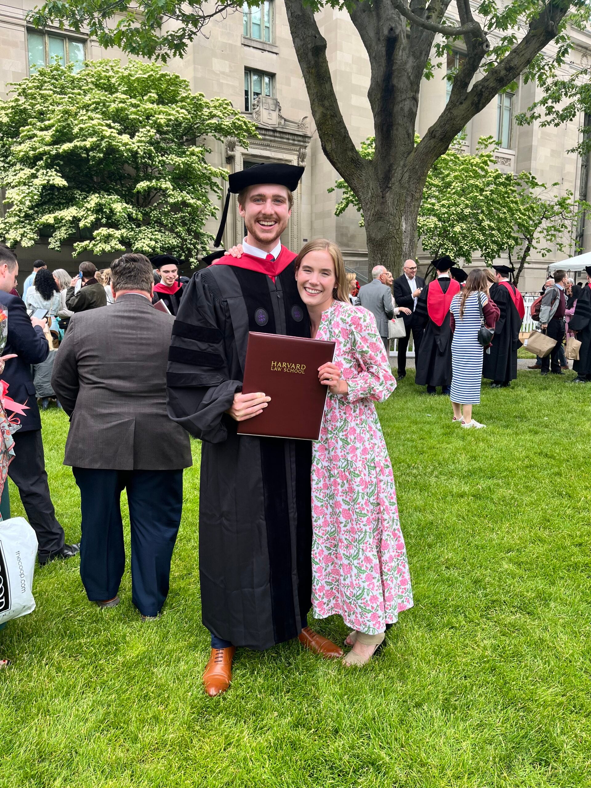 Couple posing on lawn on graduation day.