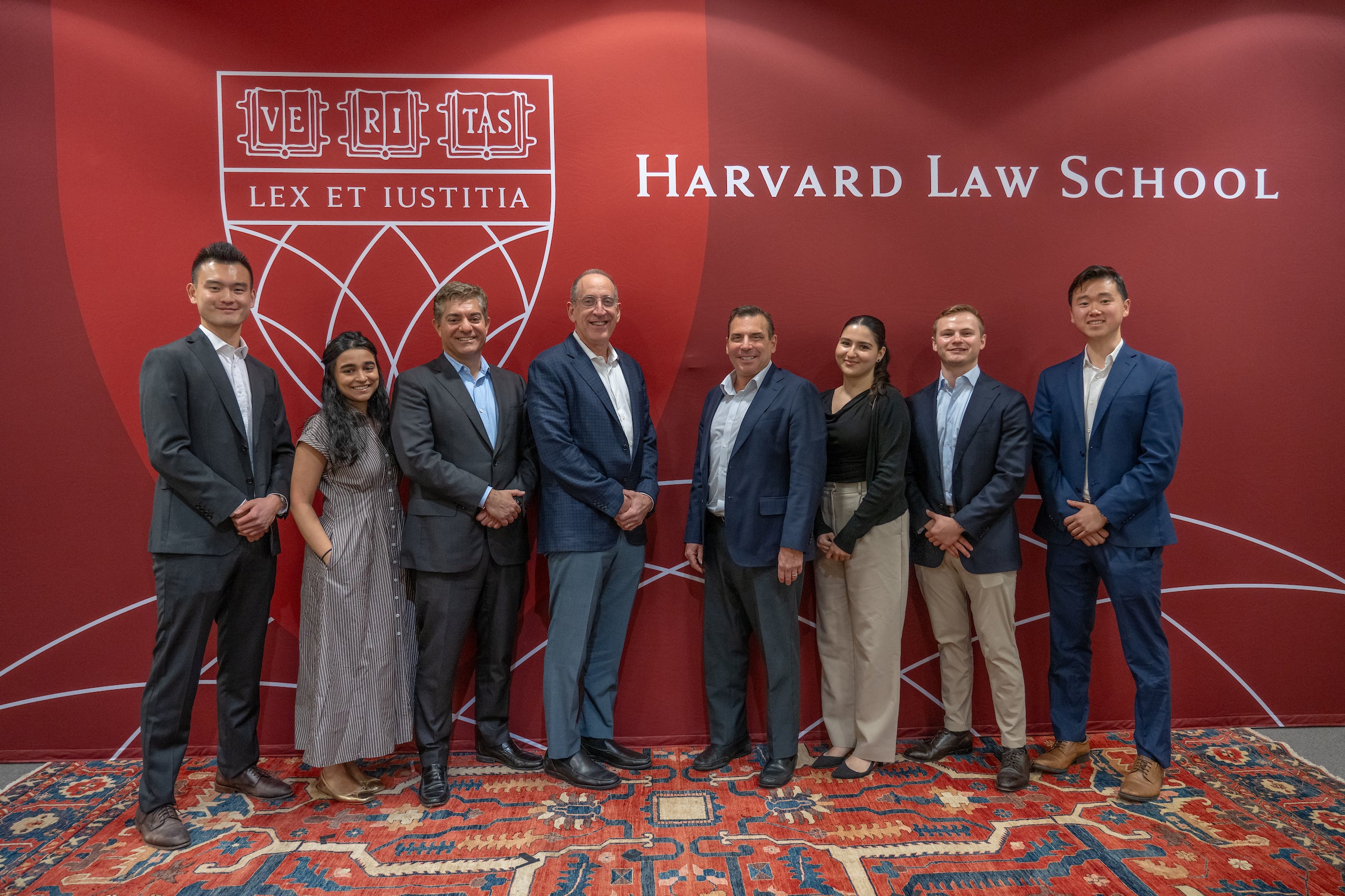 Navid Mahmoodzadegan, Howard Widra, and Andy Saperstein posing with members of the Harvard Association for Law and Business.