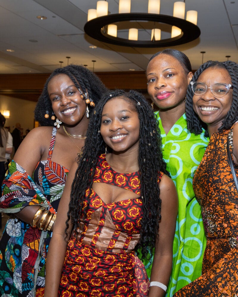 Four women huddle together for photo.