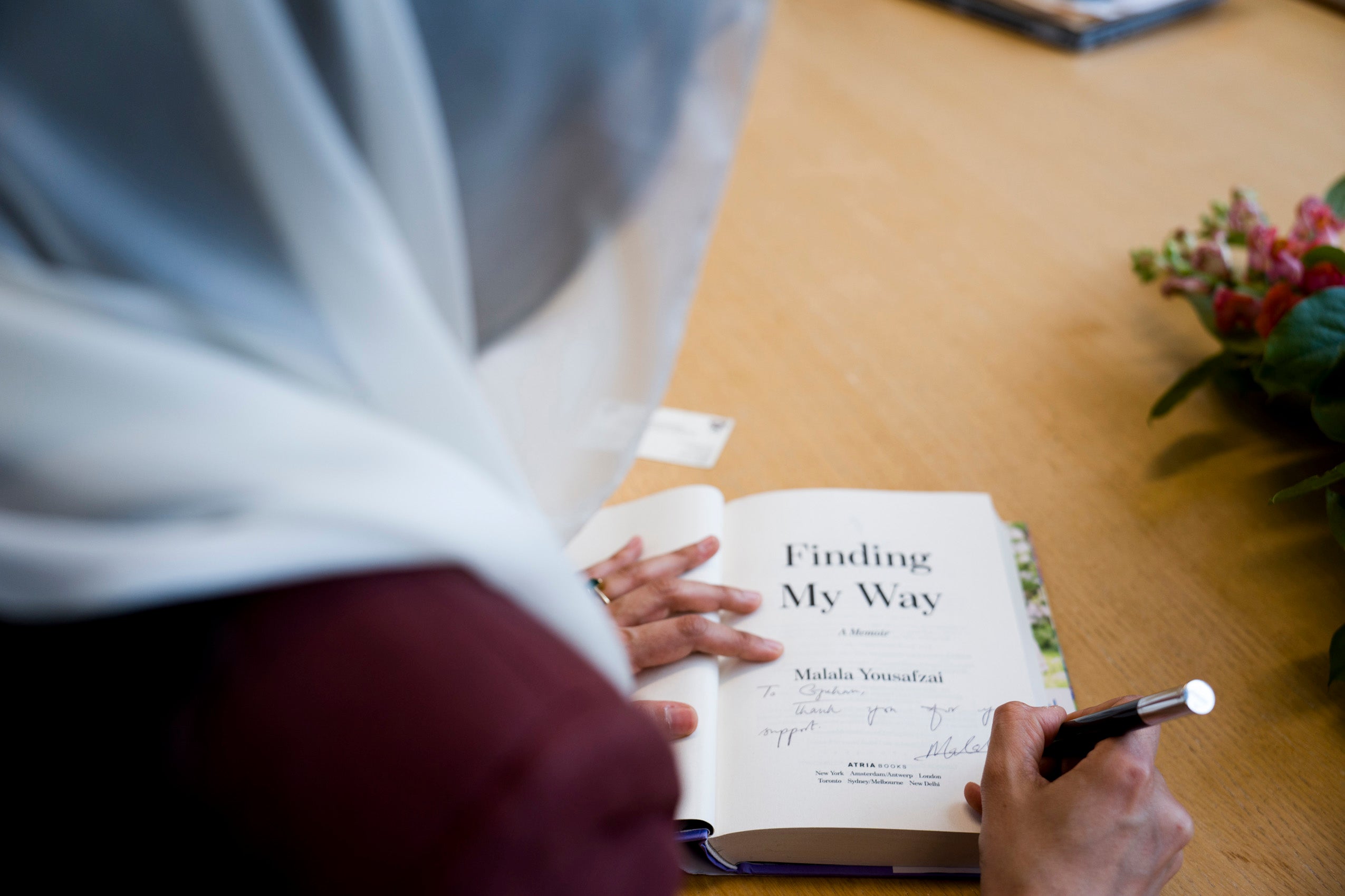 Malala Yousafzai signing a copy of her book 