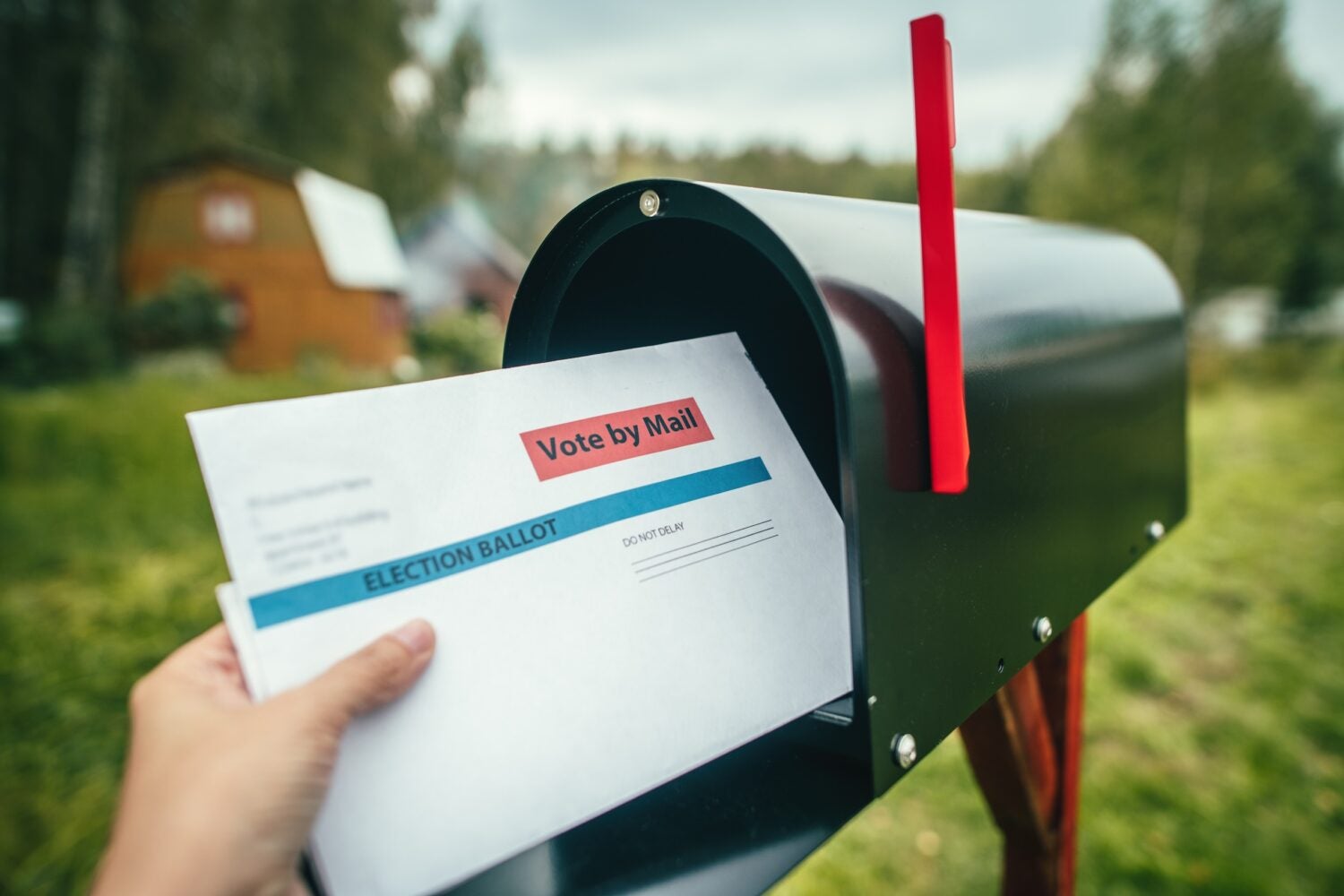 Mail in ballot being put in a mailbox.