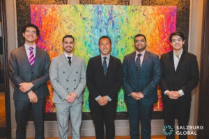 four men posing with Professor Mark Wu in front of a painting