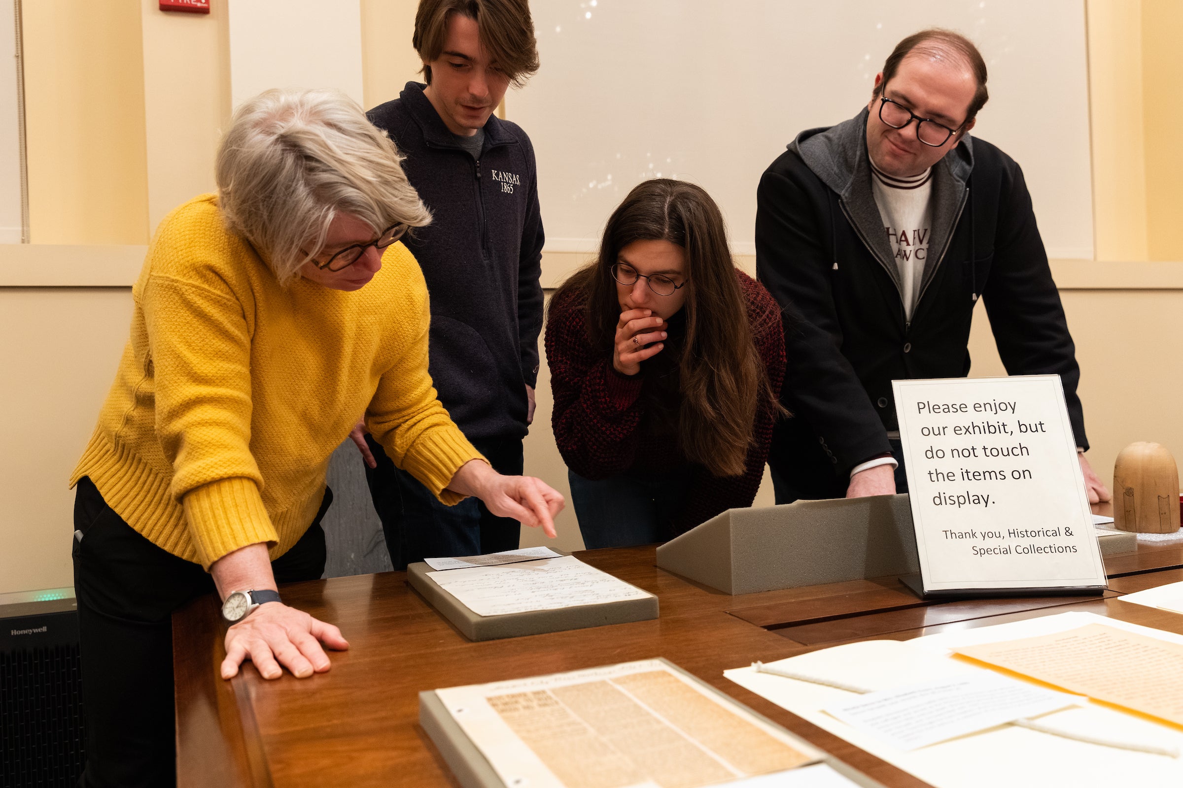 Jill Lepore examines an item while students look on.