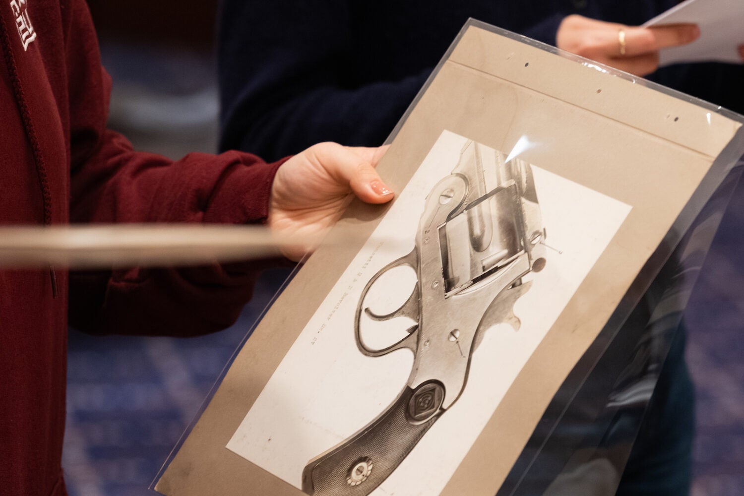 A students examines an close-up image of a pistol.