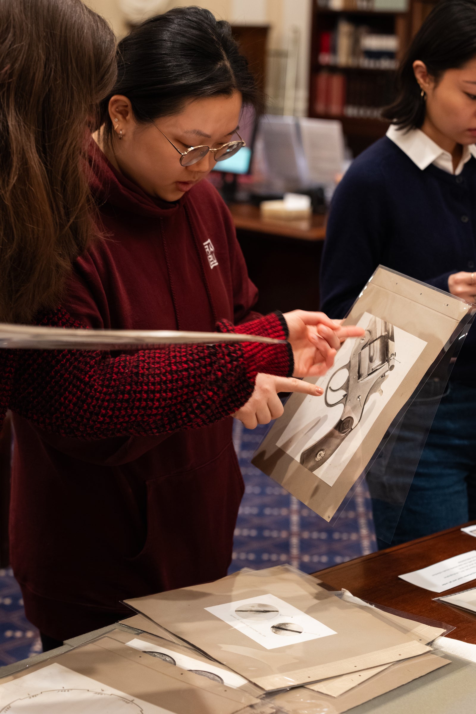 A student examining an image of a pistol from the Historical & Special Collections.
