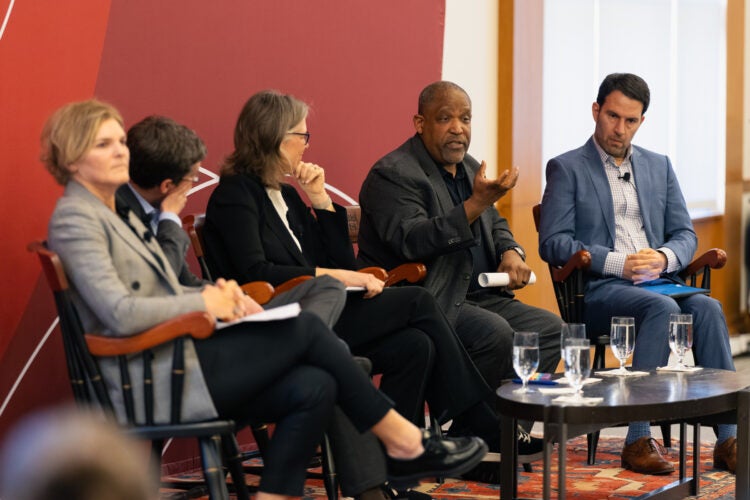 Ronald Sullivan speaks as other panelists listen.