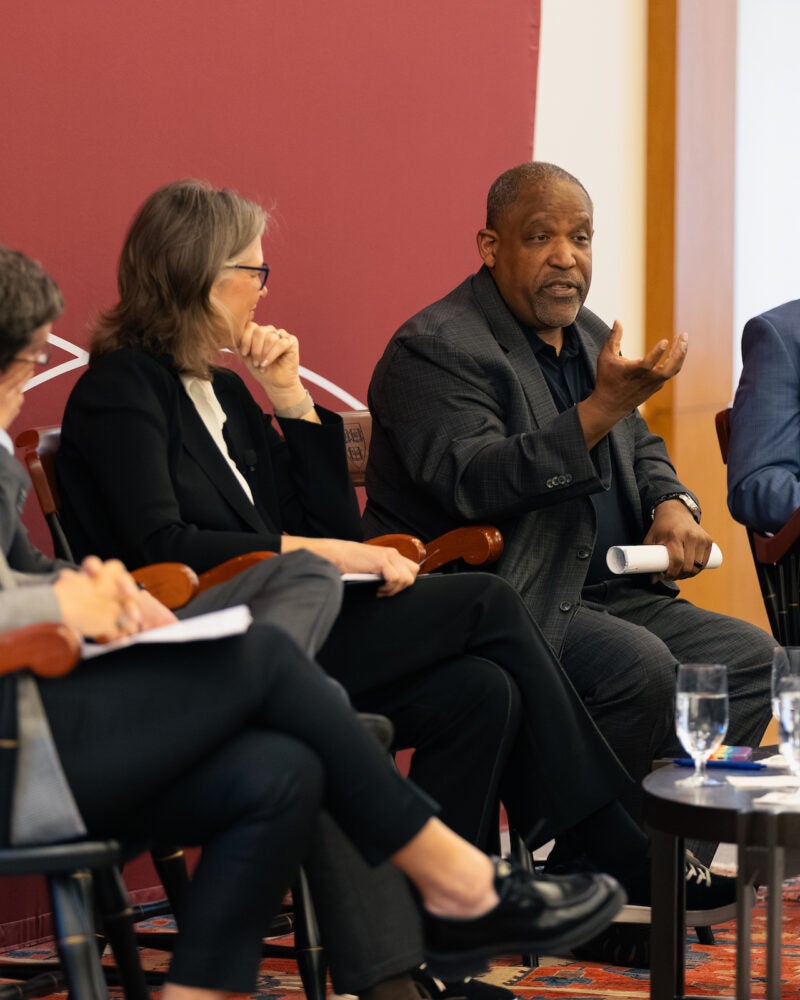 Ronald Sullivan speaks as other panelists listen.
