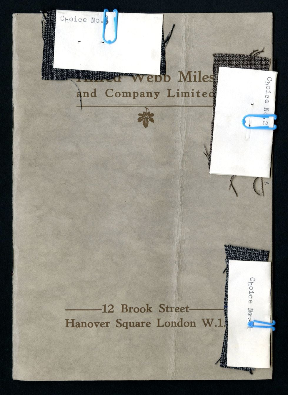 Cover of a booklet with three labeled fabric samples clipped to the cover.