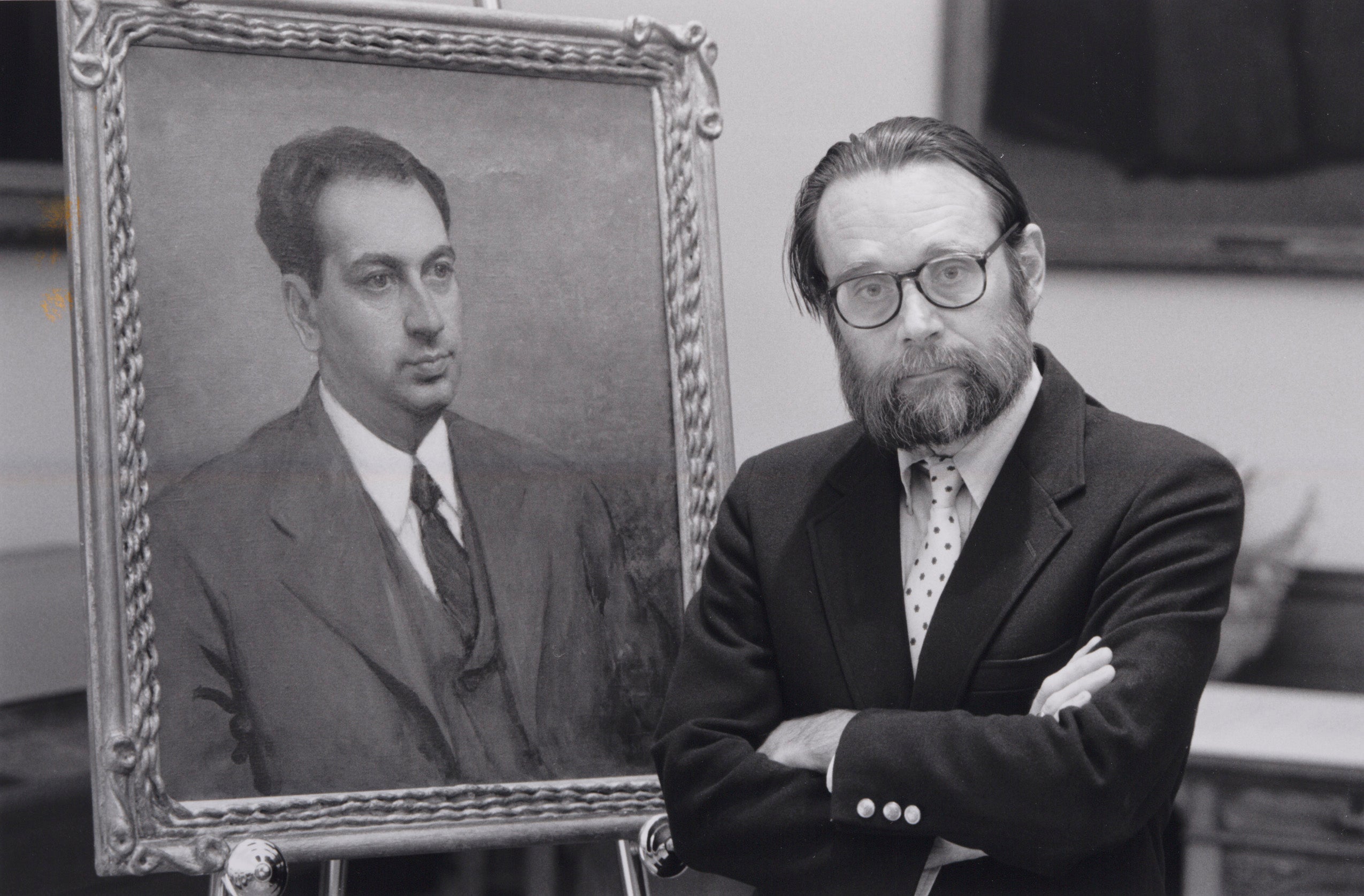 Charles Donahue in front of a portrait of a young Paul Freund.