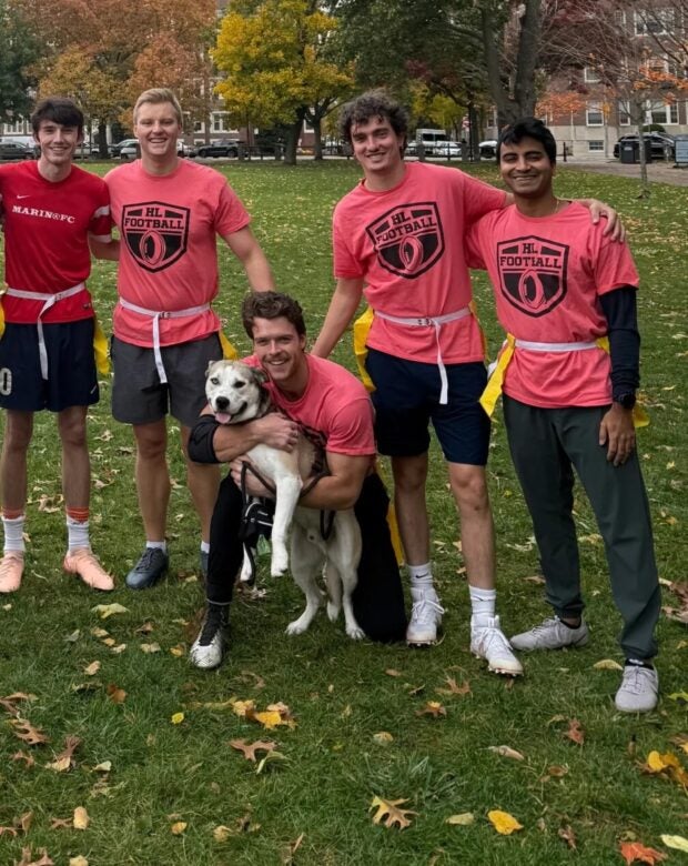 dog surrounded by flag football players.