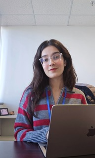A girl sits at her laptop in an office