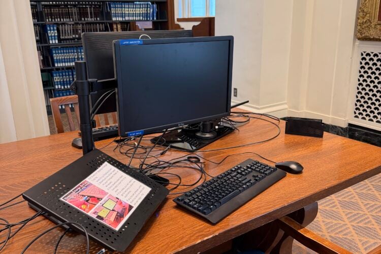 A computer at a desk in the library.