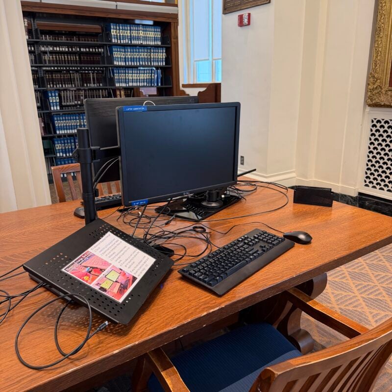 A computer at a desk in the library.
