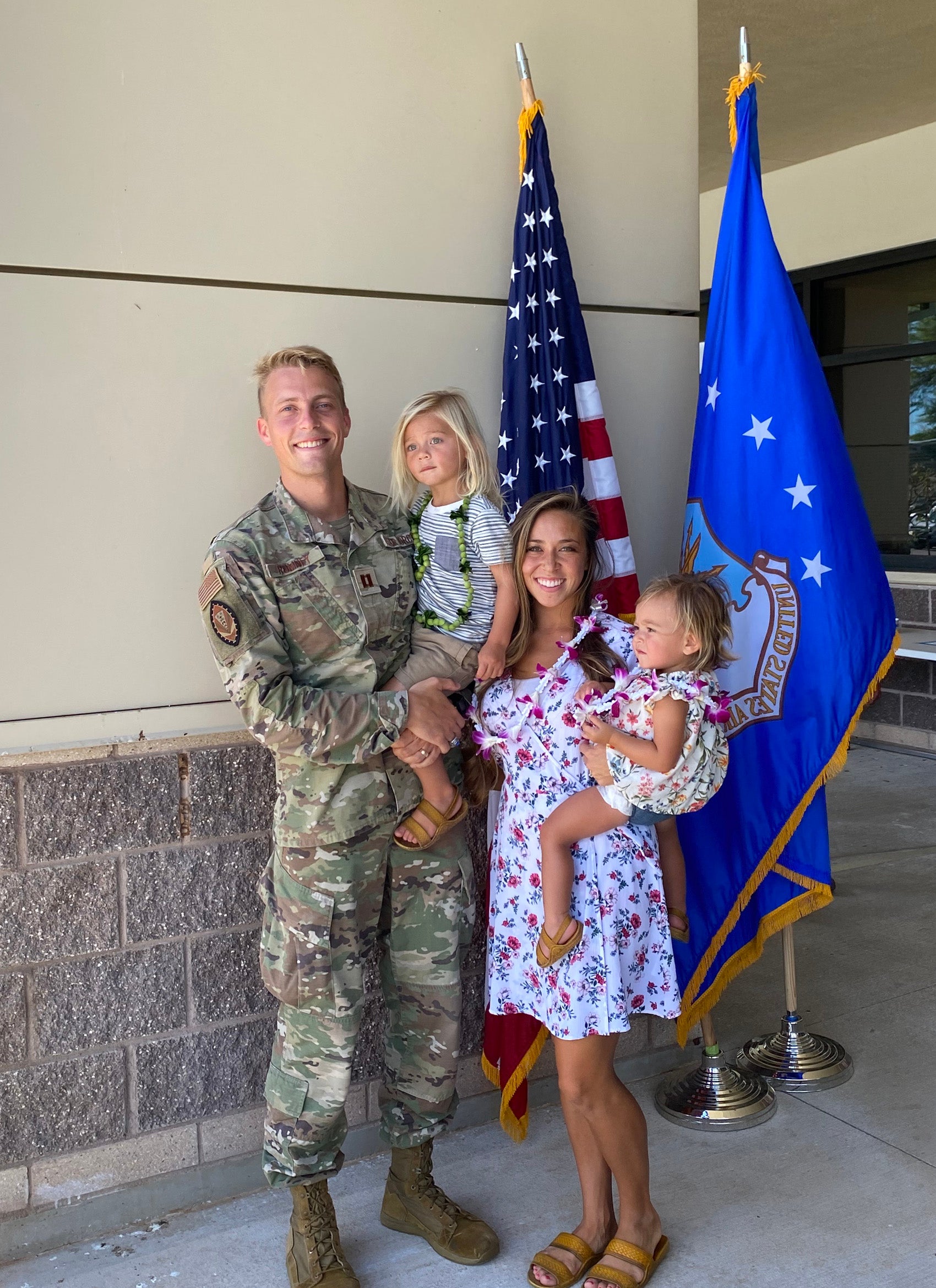 A man in uniform with his wife and two of his children.