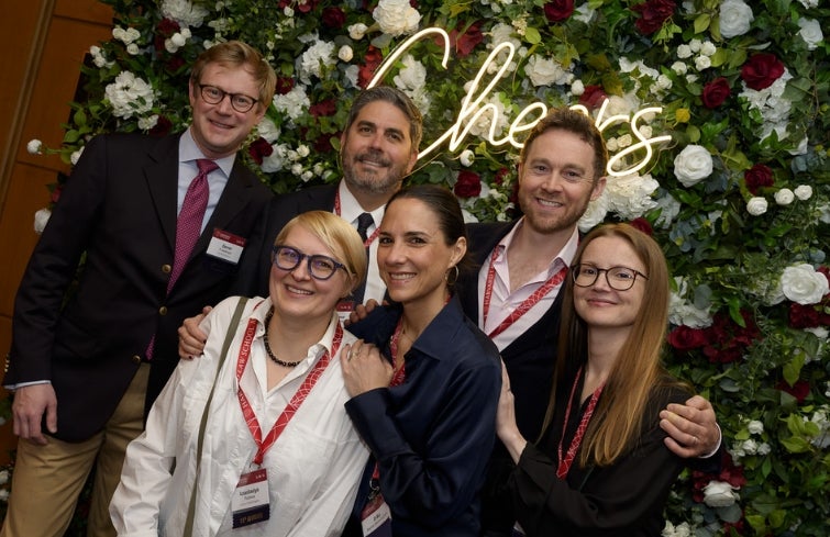 Alumni posing together against a flower background