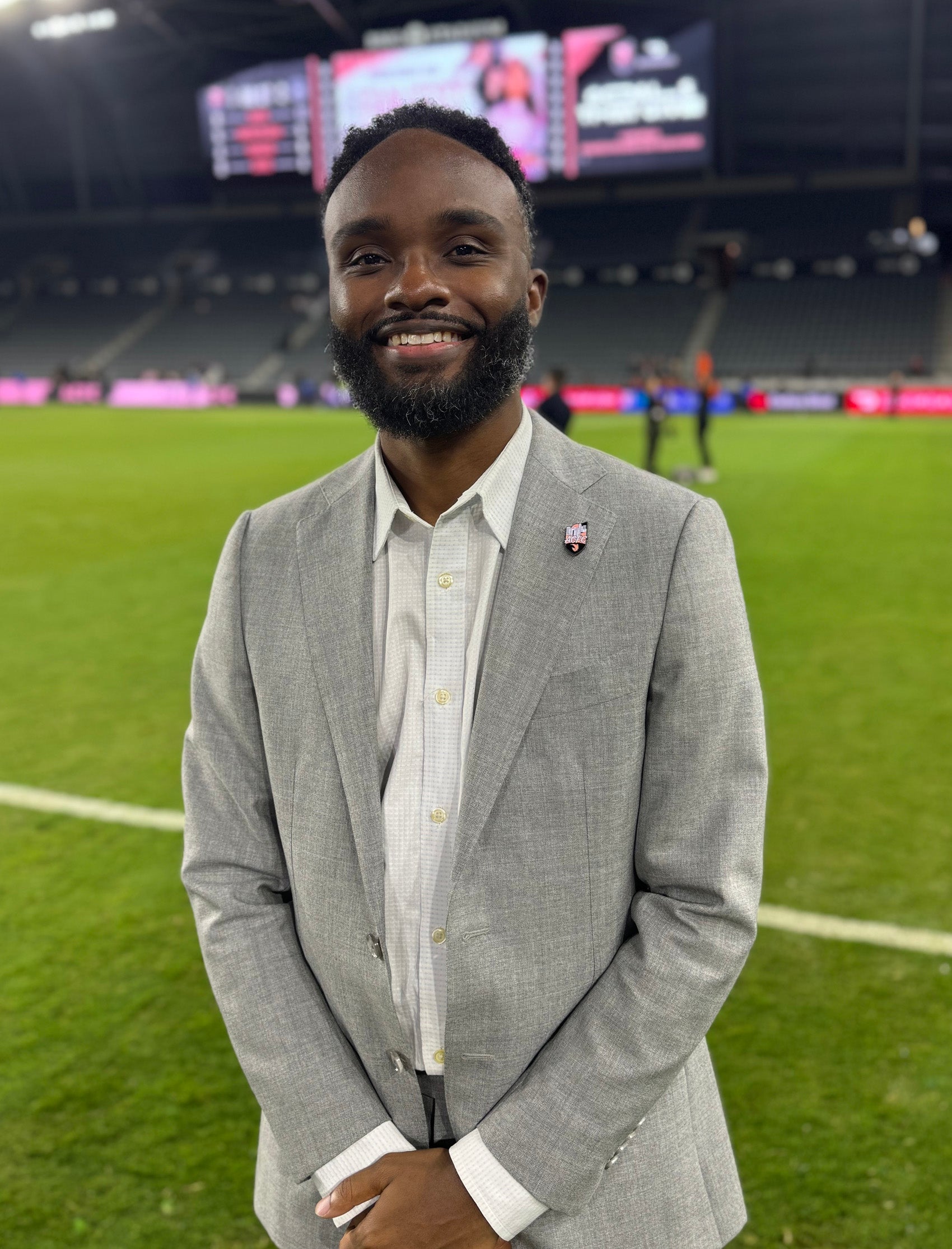 Derrick A. Davis Jr. posing in the center of a football field.