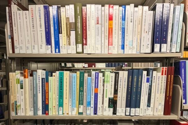 Spines of Chinese legal studies books on a library book shelf.