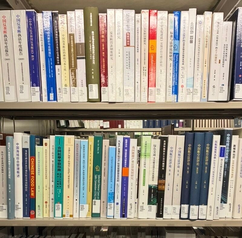 Spines of Chinese legal studies books on a library book shelf.