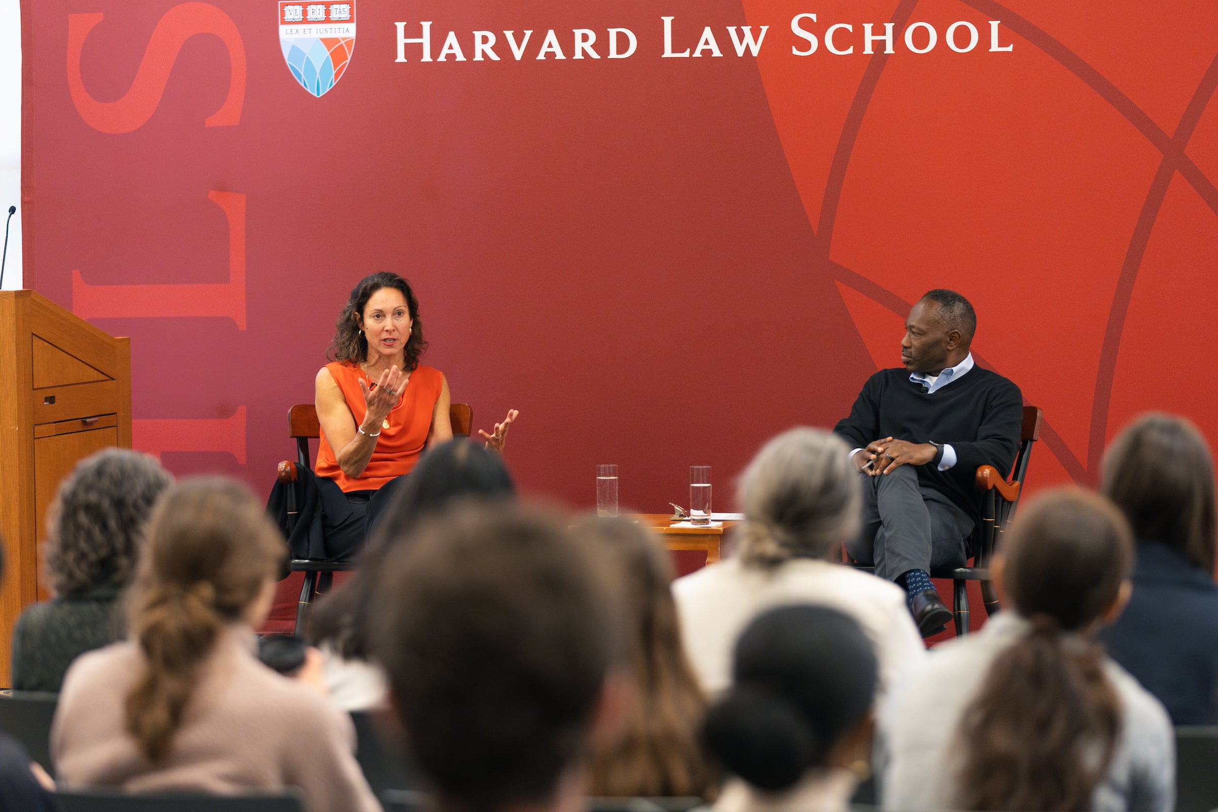 Emily Bazelon and Guy-Uriel Charles sit on a stage and speak in front of an audience.