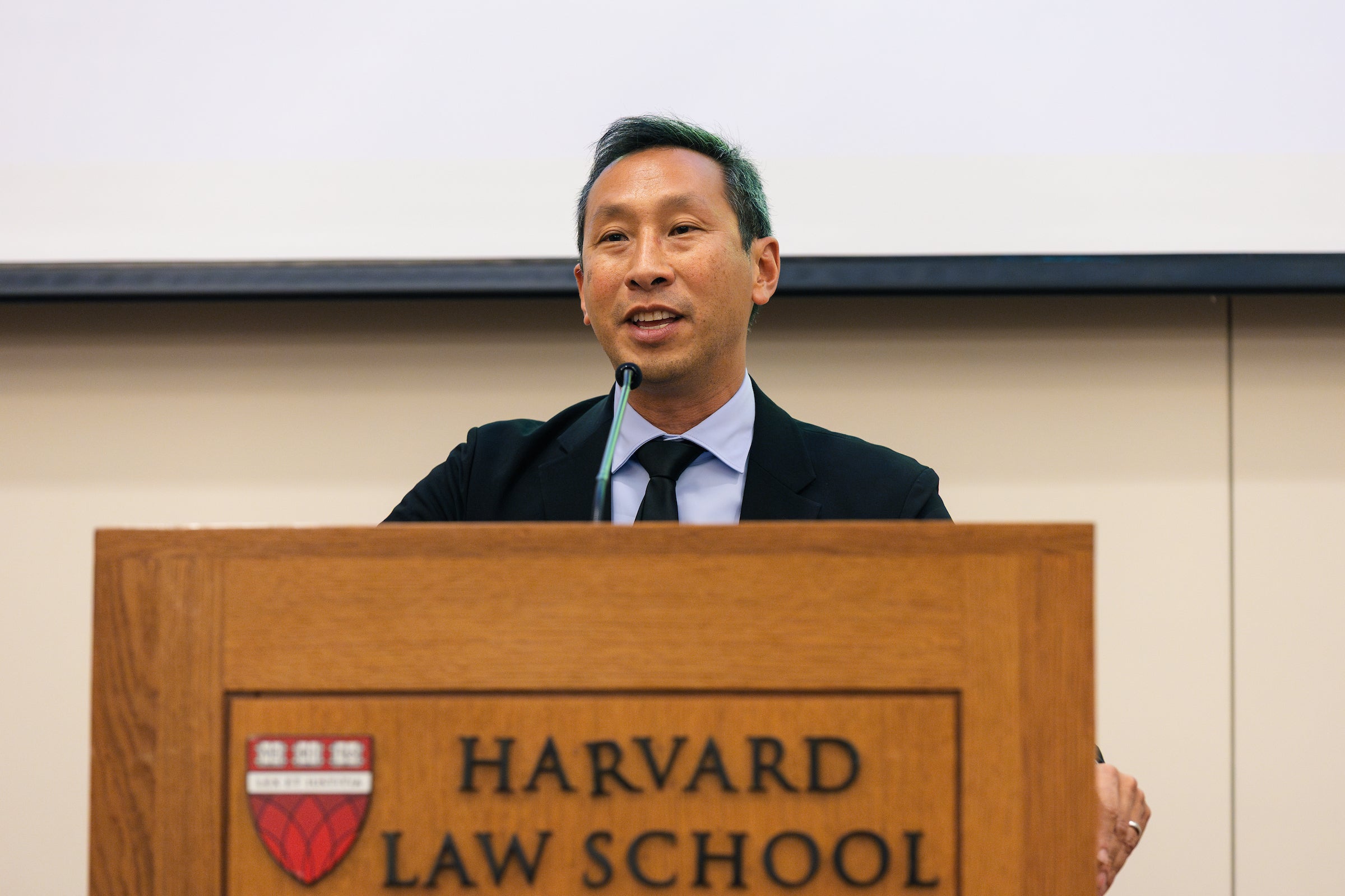 Mark Wu speaking at a podium.