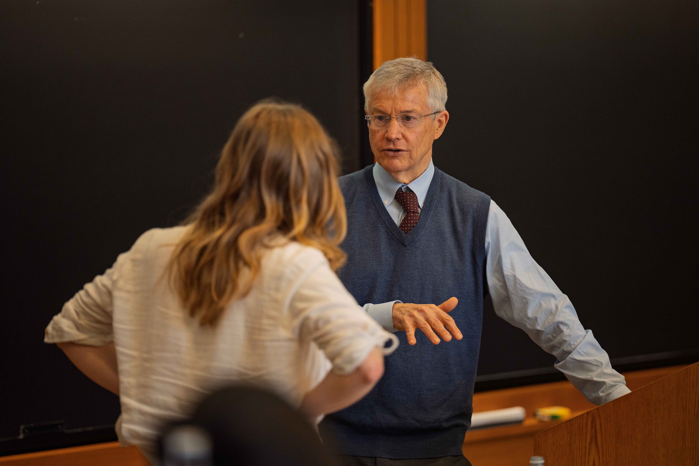 Professor Howell Jackson speaks to a student in a classroom.