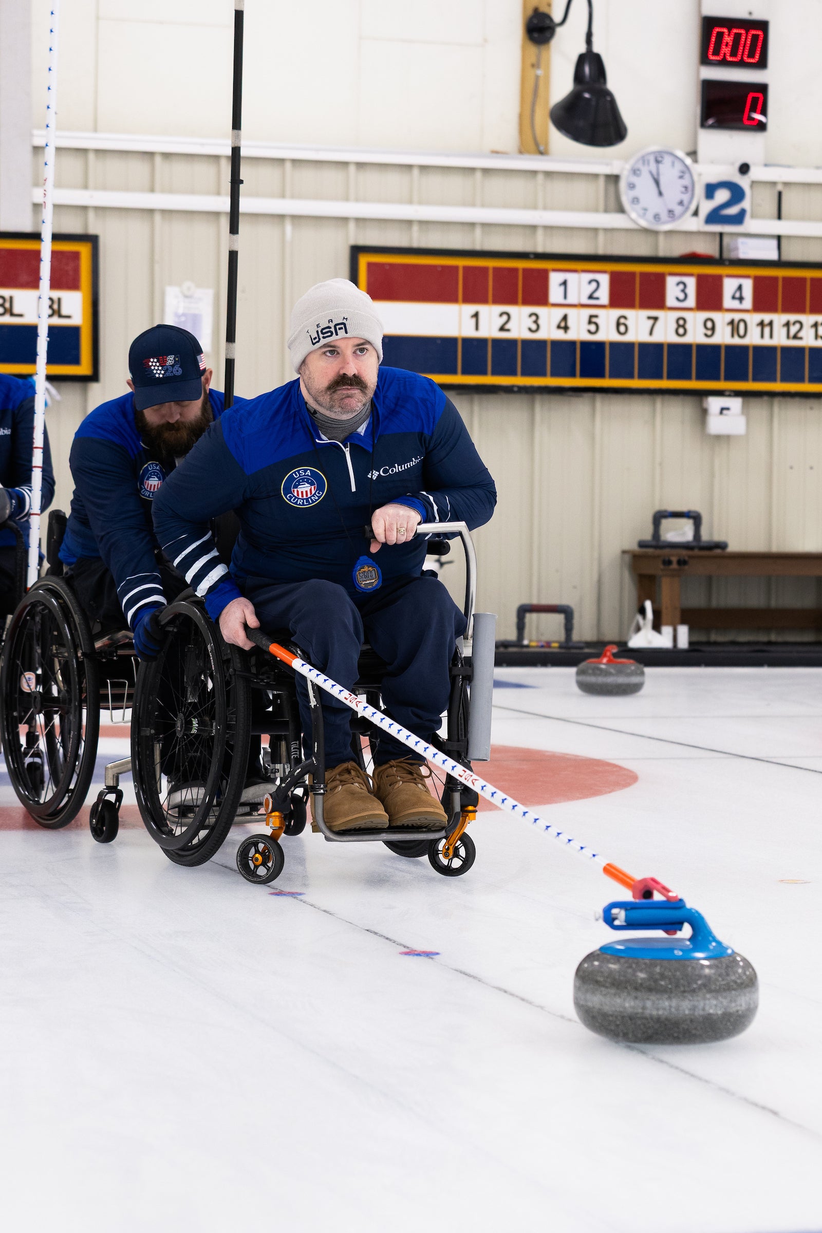 A man in a wheelchair curling.