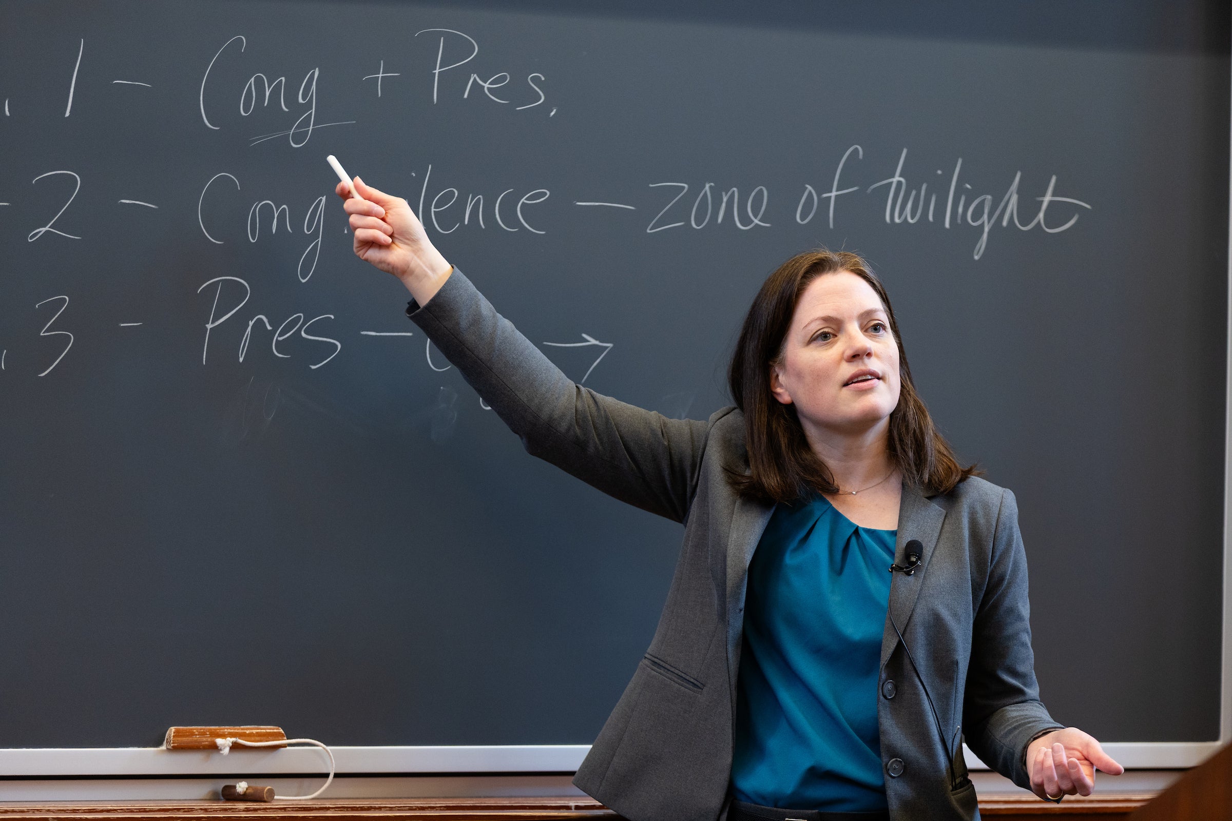 Professor Kristen Eichensehr points at a chalkboard as she teaches a class.