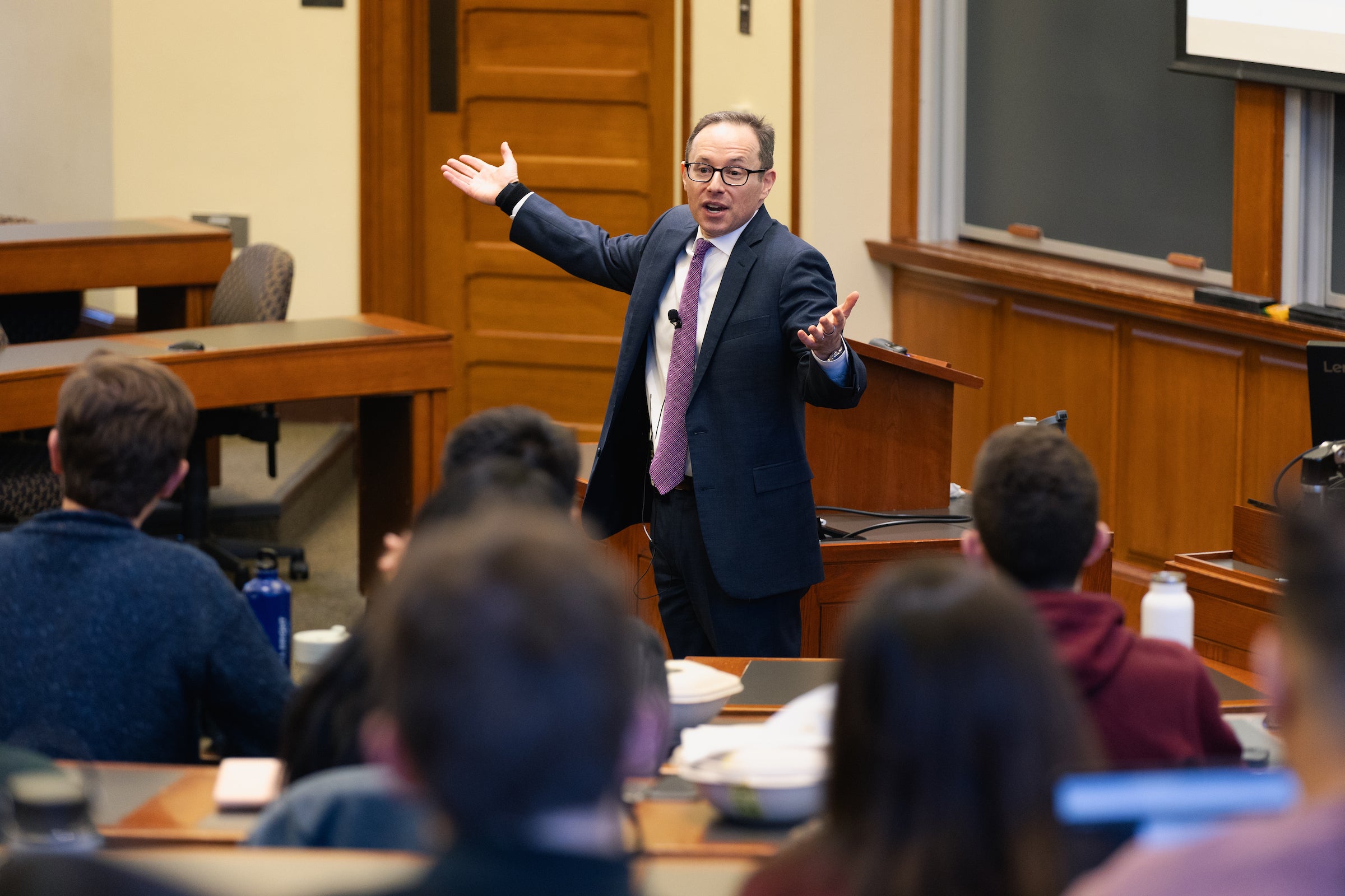 Professor Robert Sitkoff addresses a classroom of student with his arms wide.