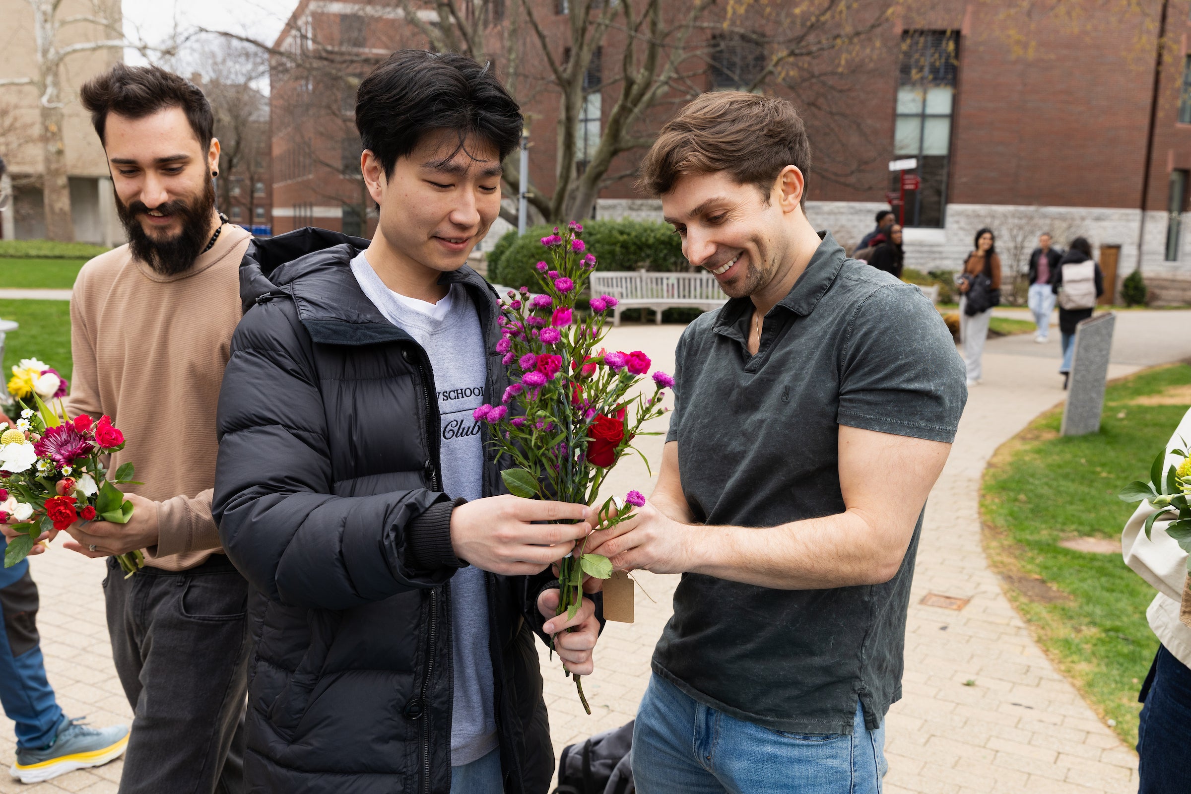 Three students create flower bouquets.