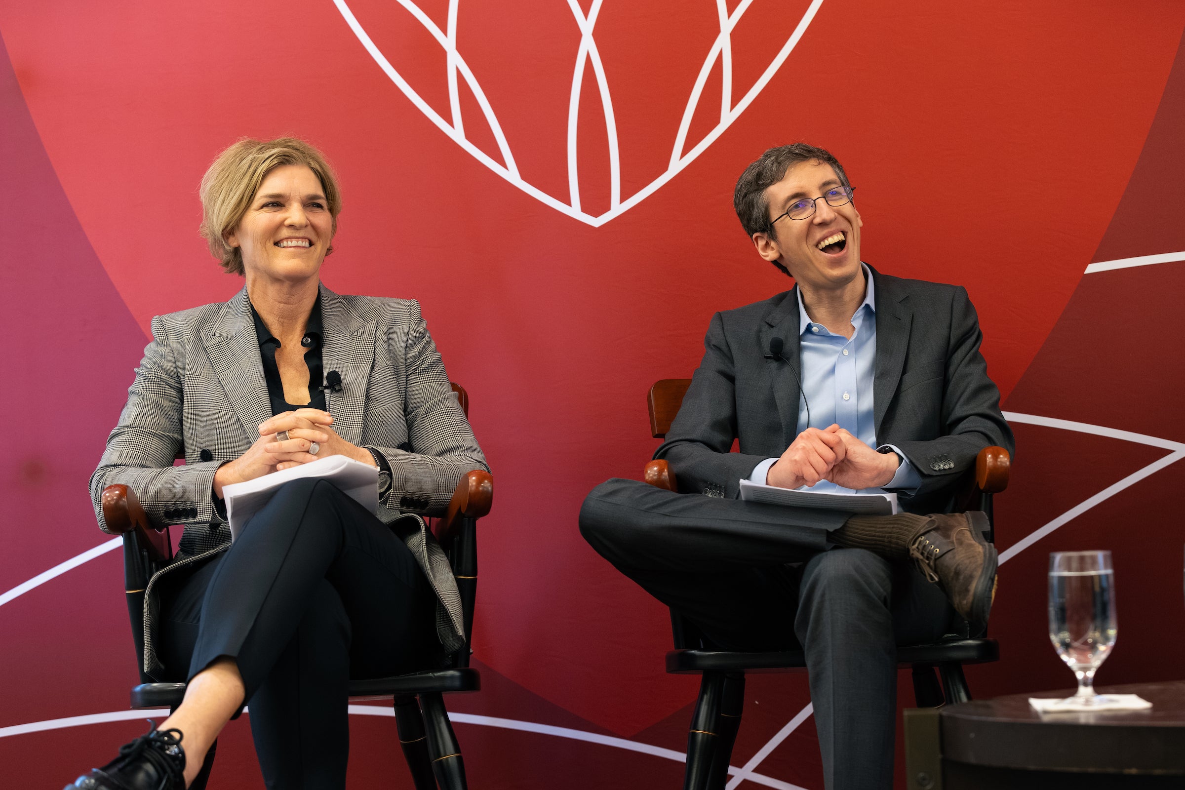 Jody Freeman and Ben Eidelson laugh while speaking on a stage.