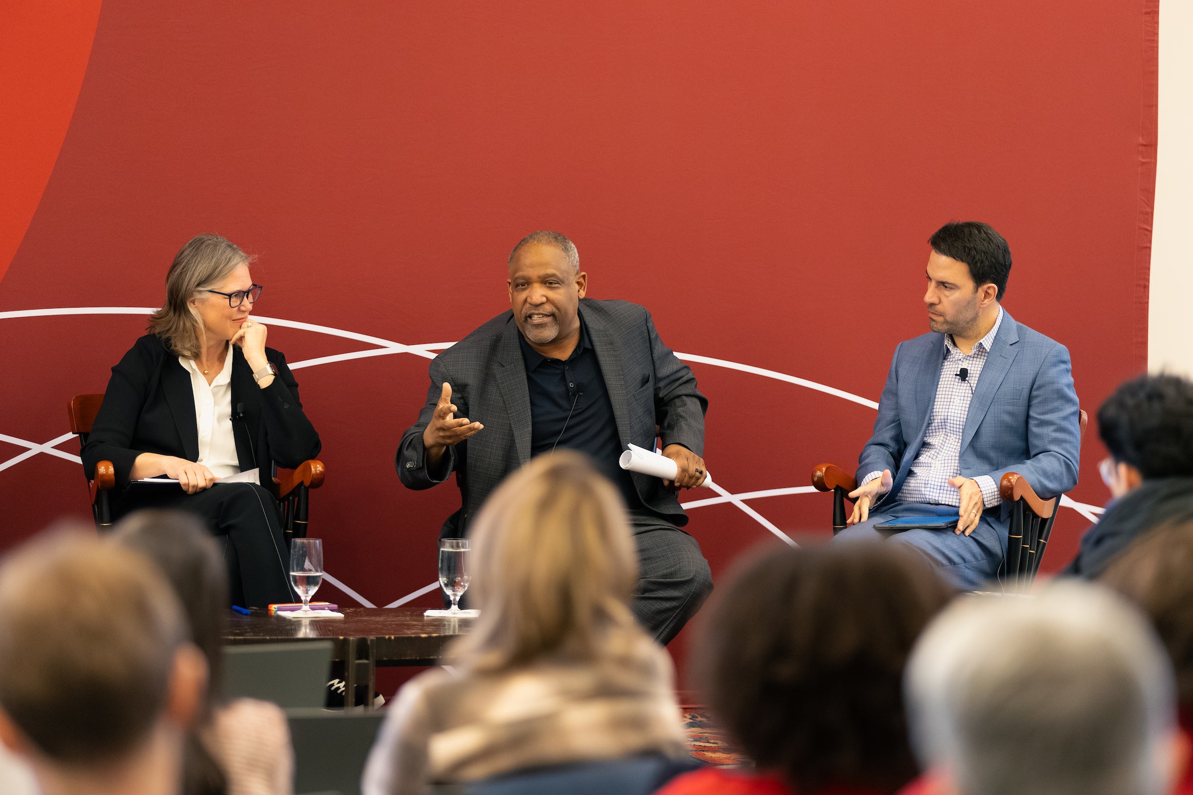 Sheila Heen, Ron Sullivan, and Nick Stephanopolous sit on a stage in front of an audience.