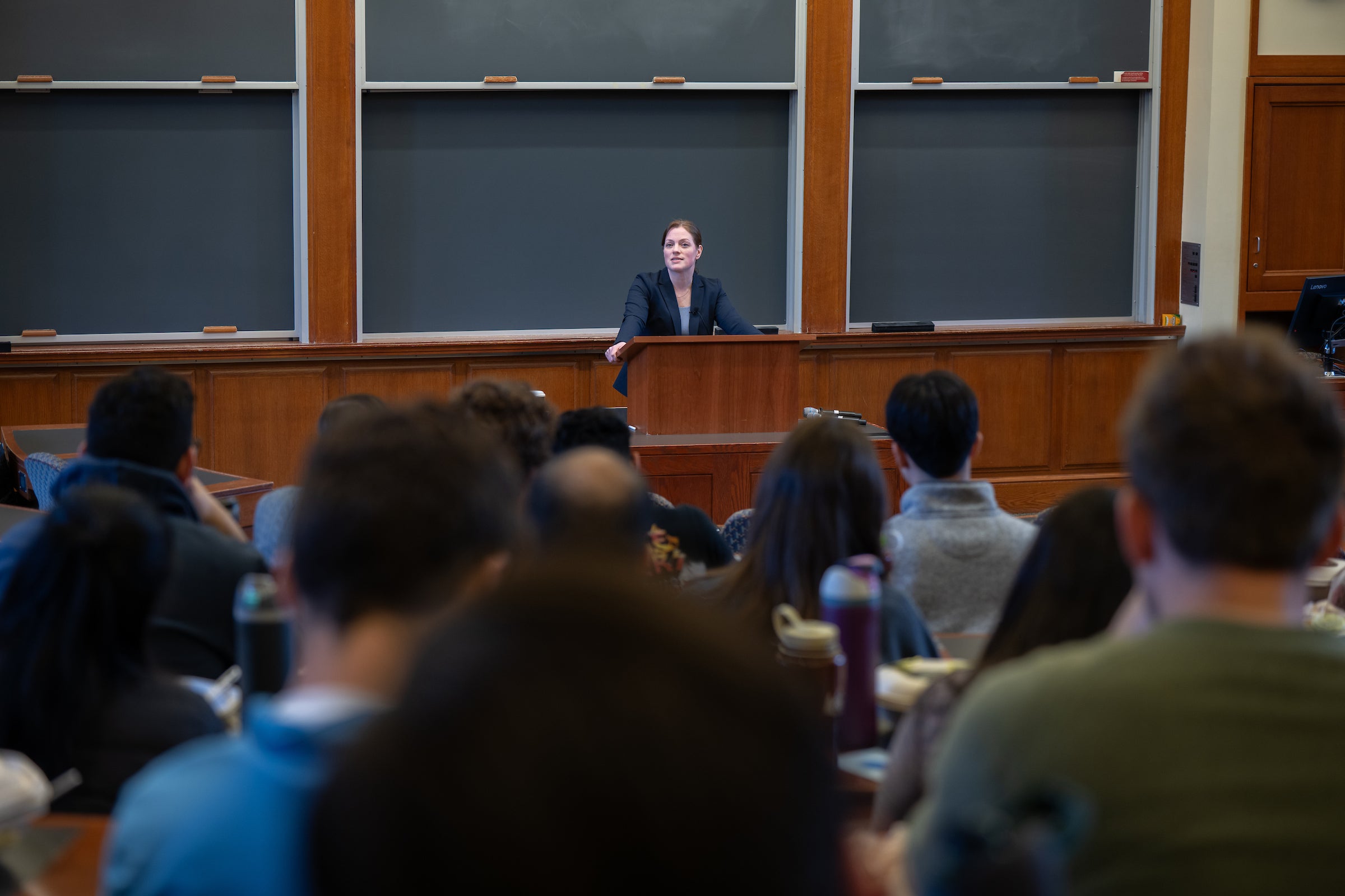 Professor Kristen Eichensehr speaks from a podium to a classroom of students.