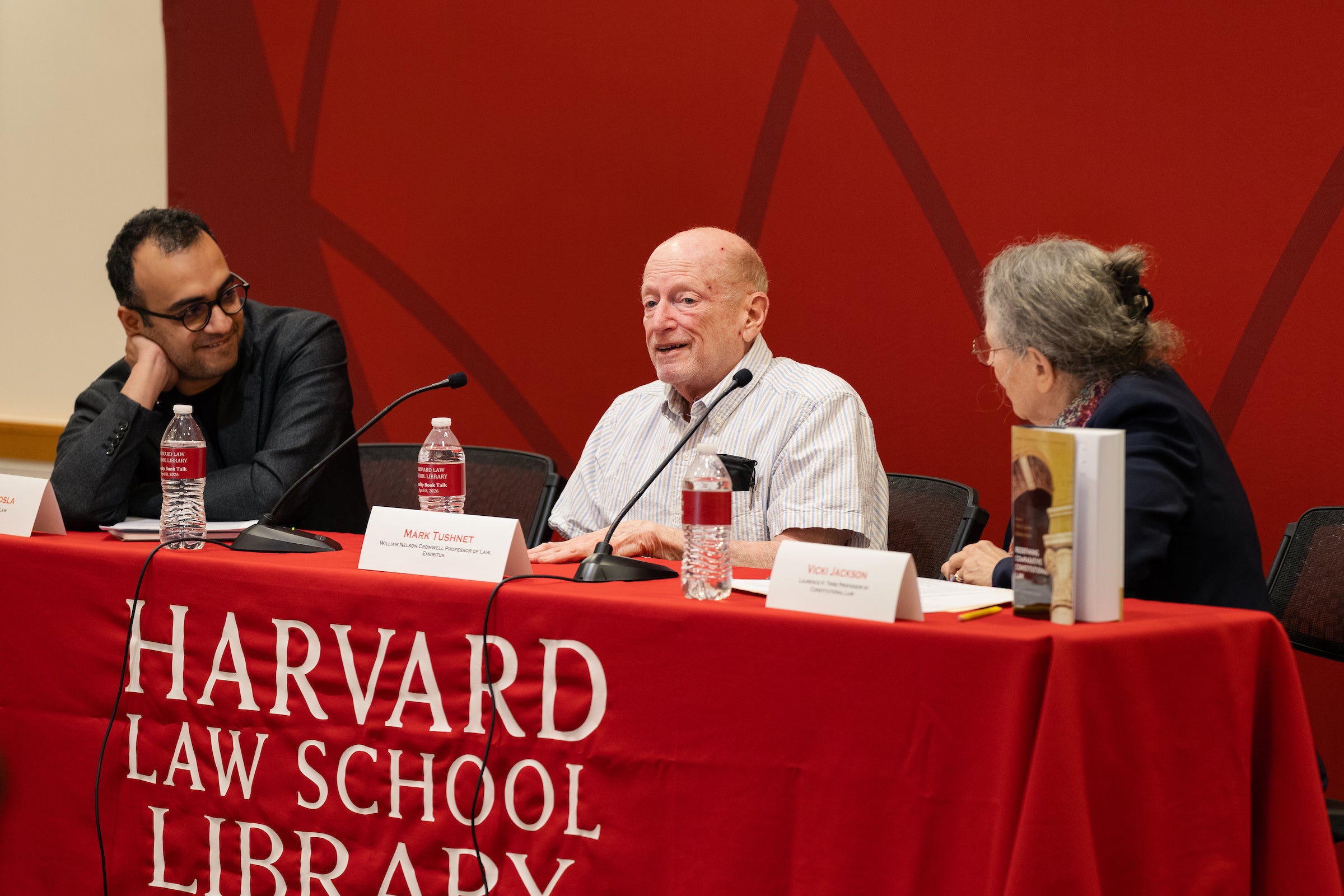 Three people speak on a panel.