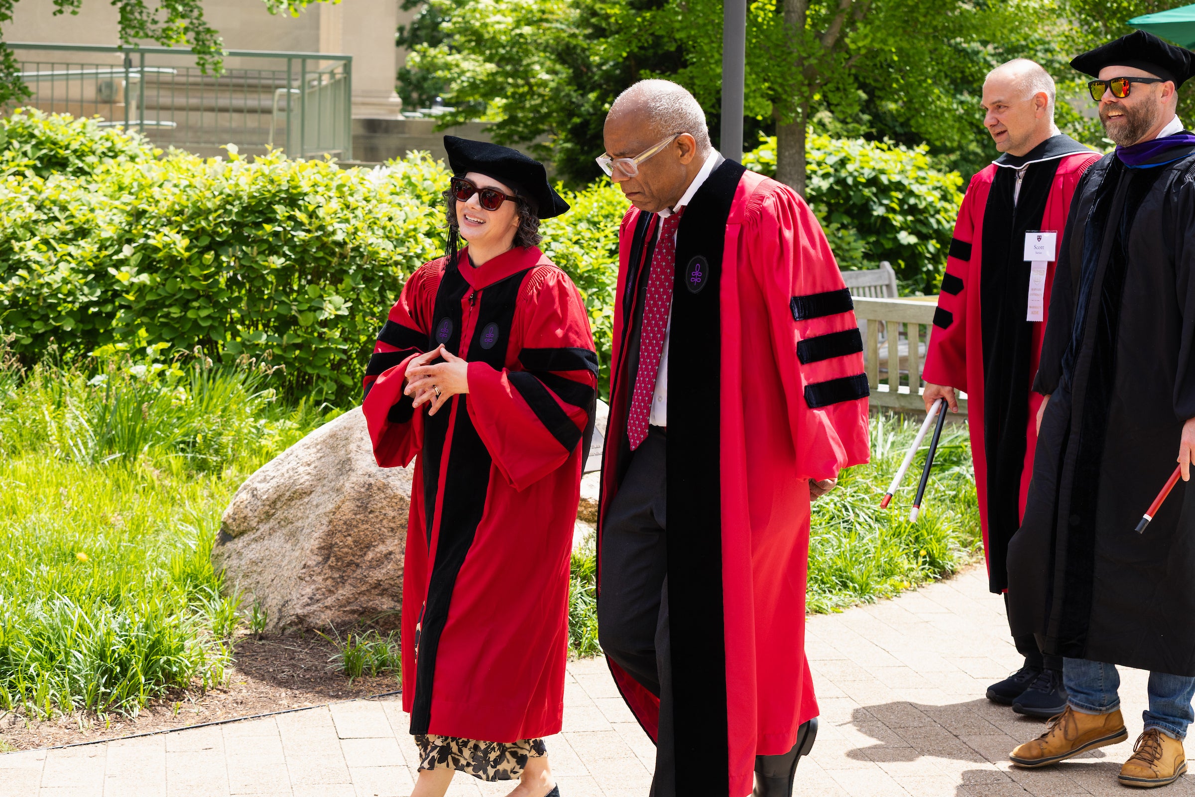 Two Harvard Law professors converse as they walk in a procession of other professors.